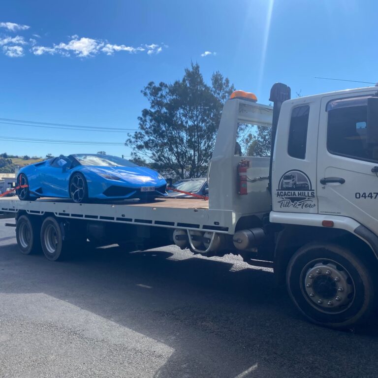 Sports car loaded on a tilt tray tow truck