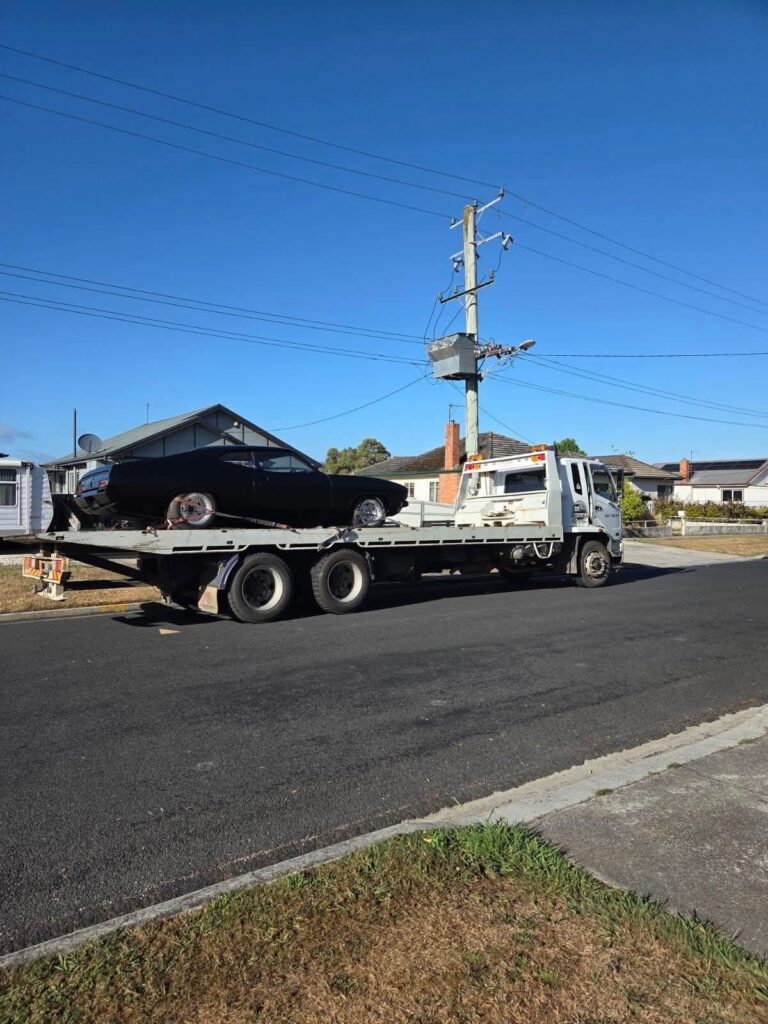 Classic car being transported on a tilt tray