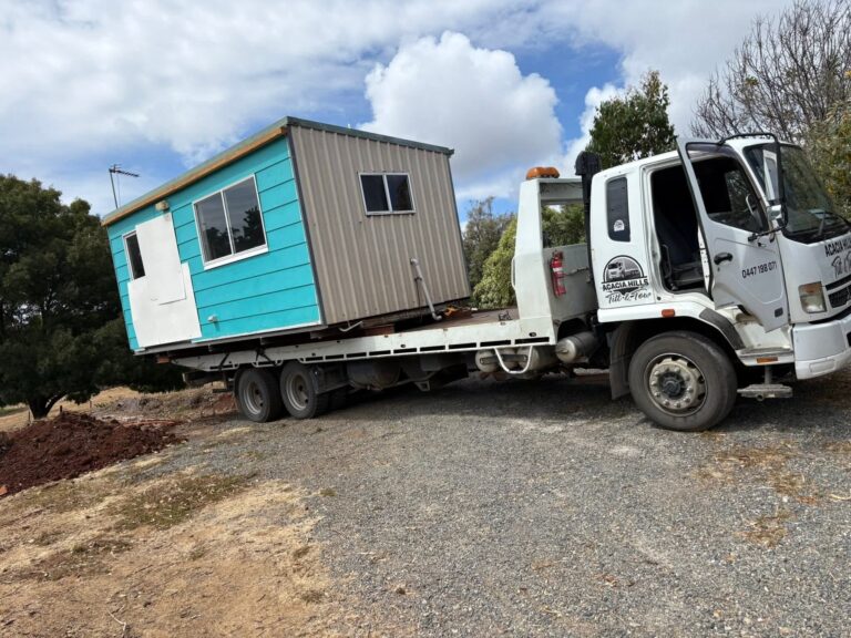 Portable site cabin transported on a tilt tray truck